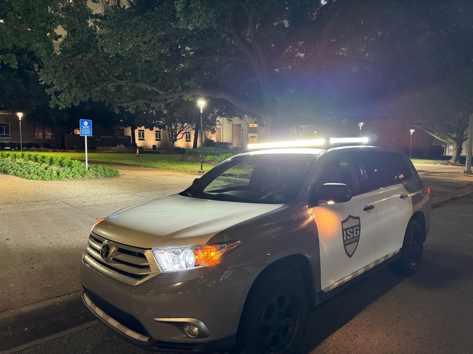 ISG patrol vehicle on a campus drive at night with its light bar on