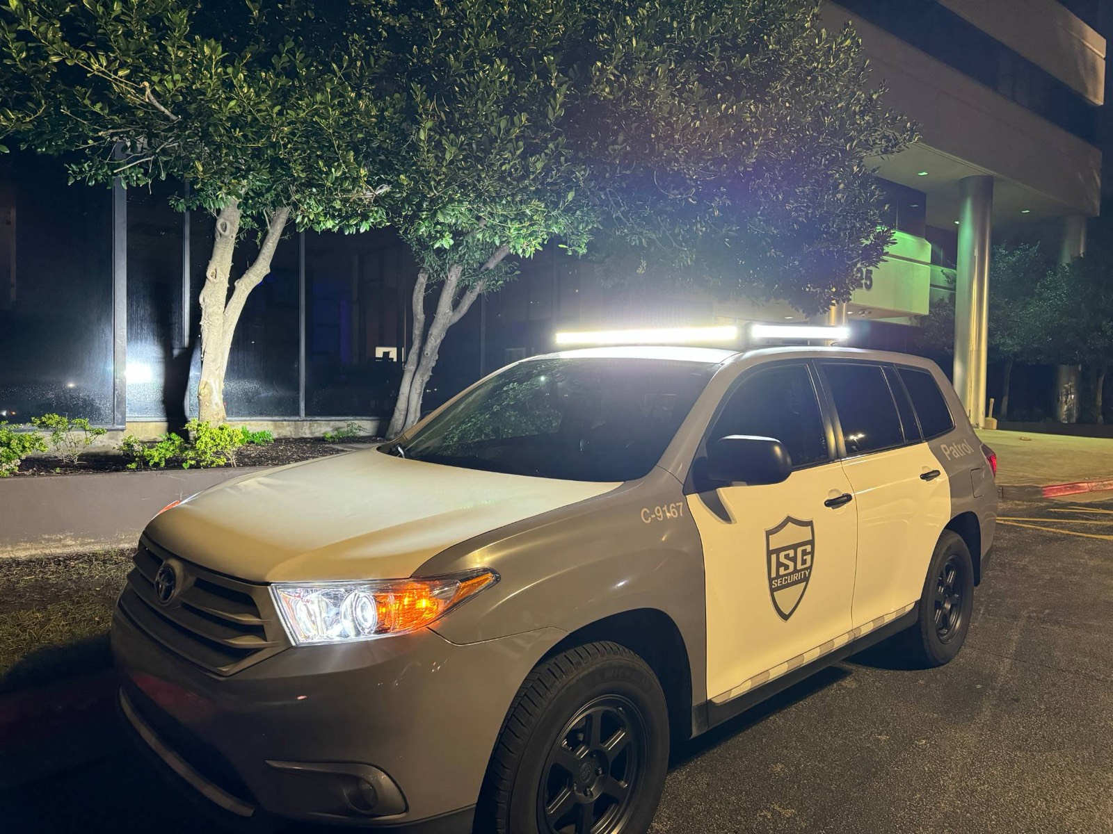 ISG patrol vehicle with its light bar on outside an office building at night